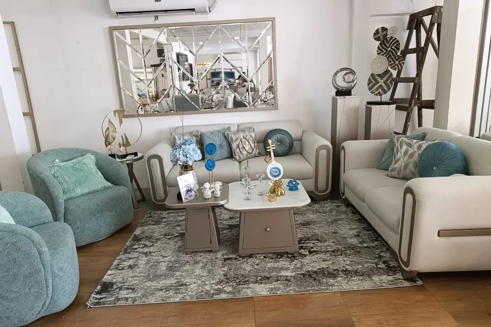 Sala con dos sofás beige y sillones tapizados en el showroom STYLHOUSE