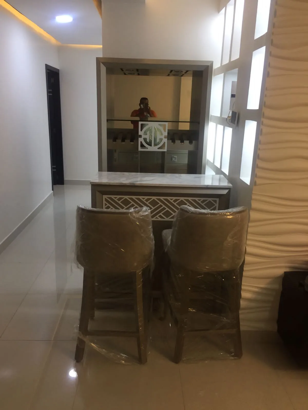 Barra de bar con panel fretwork y nicho espejado