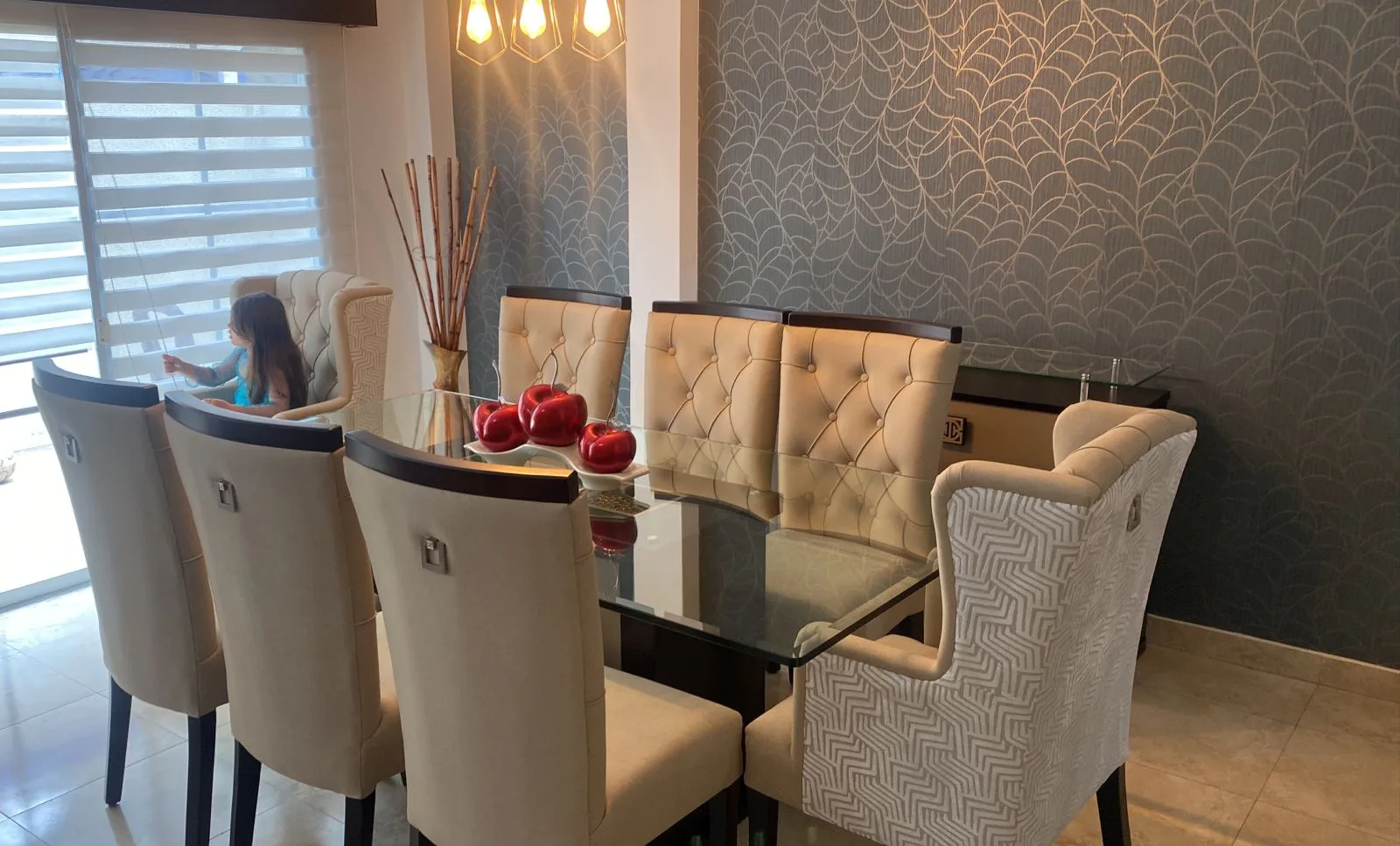 Comedor mesa vidrio con comida servida y comensales