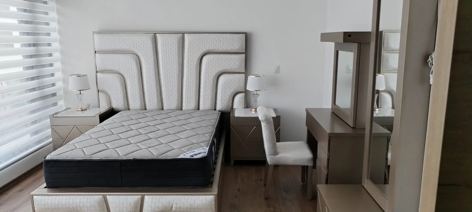 Cabecera de cama con textura tejida en canales curvos y remate metálico triangular (estilo art-decó)