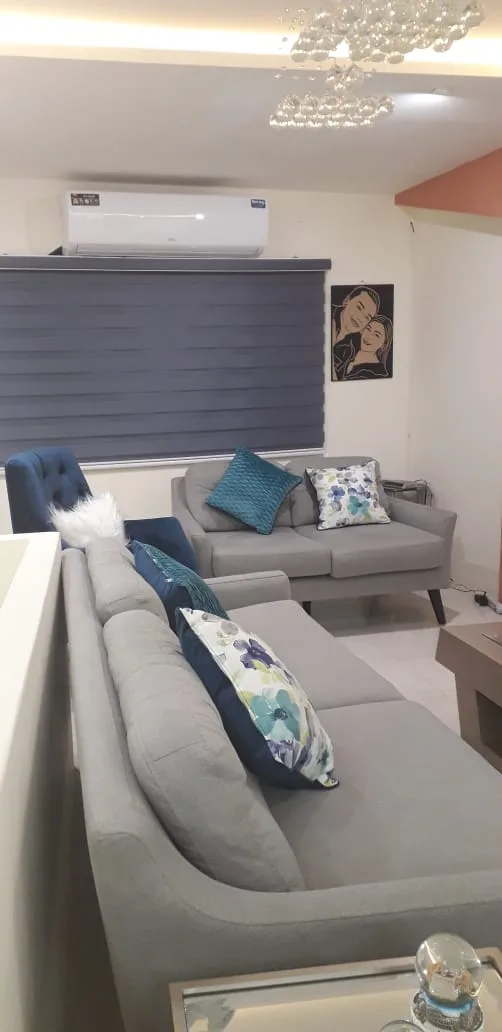 Sala a medida — sofá gris con sillón azul capitoné