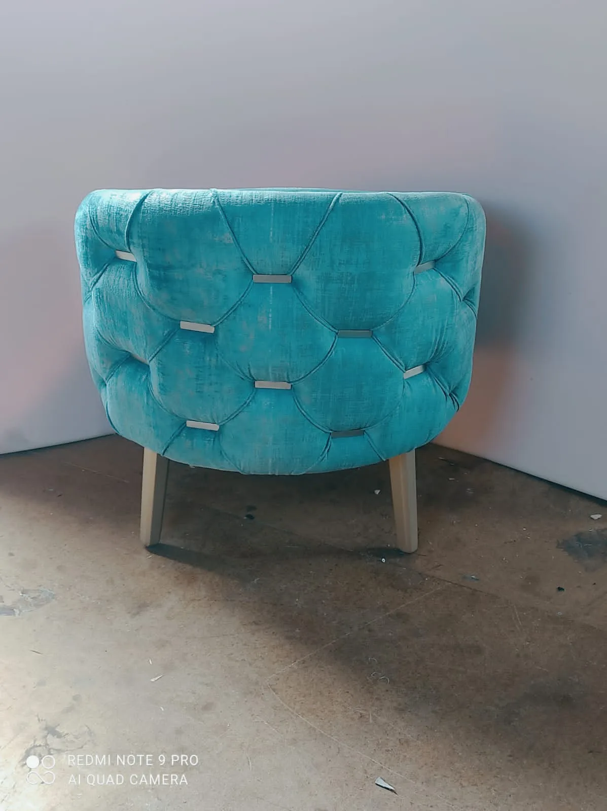 Sillón capitoné azul petróleo con patas cromadas